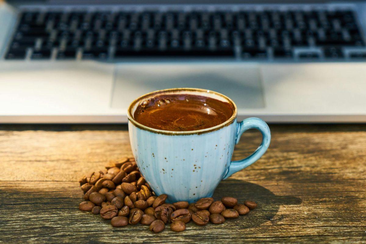 close up photo of coffee cup beside coffee beans