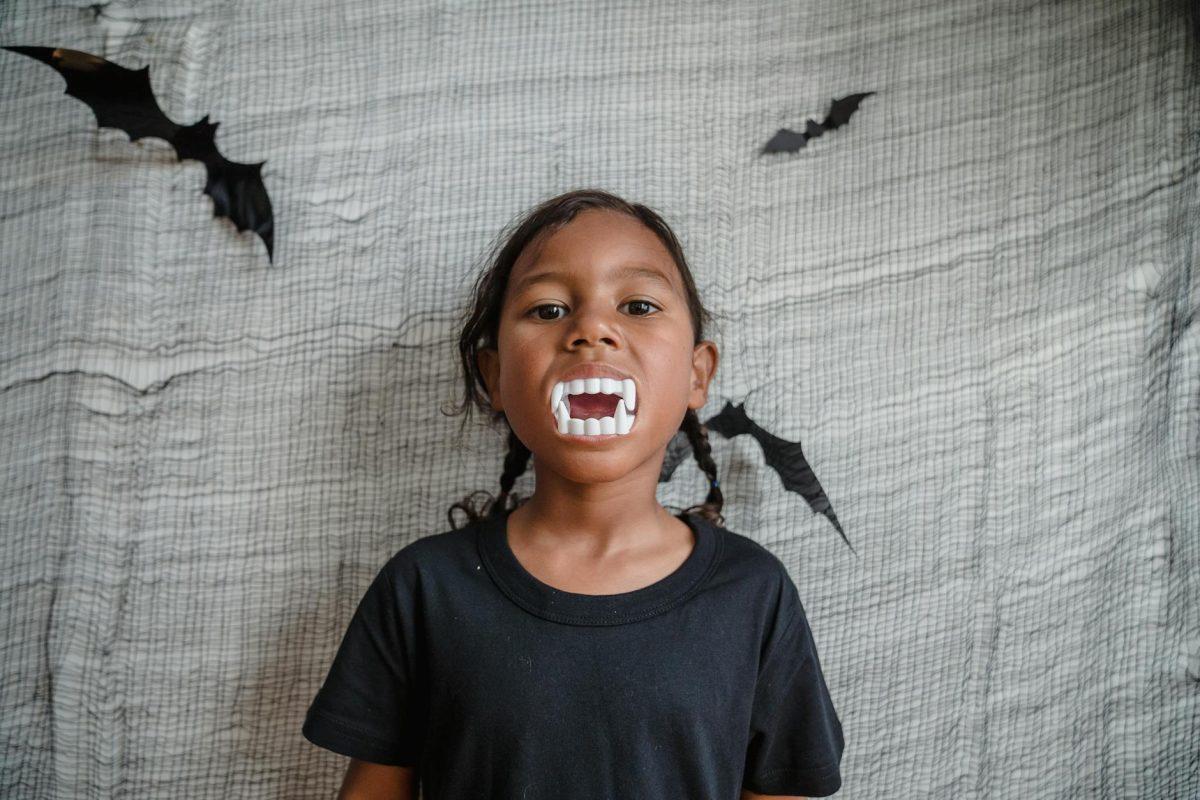 young girl with toy teeth in mouth